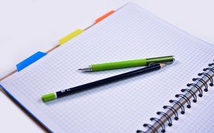pen and pencil are on the notebook