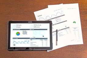 business analytics on a tablet and printed business plans