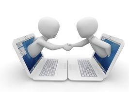 handshake over white laptops