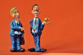 ceramic figures of men on an orange background