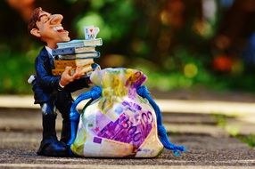 funny figure of a tax consultant near a money bag
