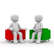 human figures sit on red and green chairs