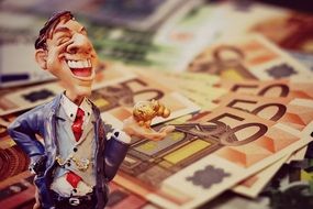 statuette of a businessman on the background of money