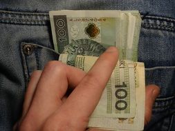 human hand takes money out of pocket