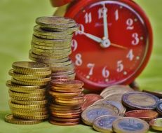 euro coins and red clock