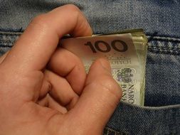 man's hand takes money out of pocket