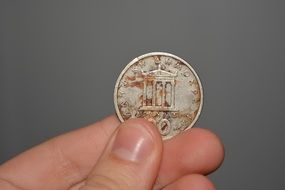 greek coin in hand