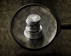 silver coins under a magnifying glass