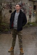 man in jacket posing near the wall