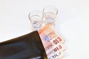 wine glasses and wallet with banknotes