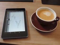 Working on a tablet with coffee