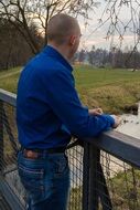 young man on a bridge in rainy weather