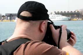 a man photographs a ship on the water