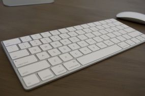 small white keyboard on a wooden table