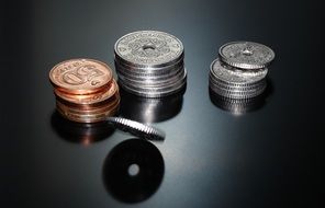 still life of coins on a dark shiny surface