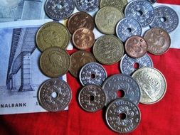 coins and banknotes on red cloth
