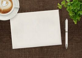 blank paper on the table near a cup of coffee