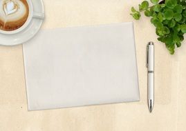 cup of coffee, a white sheet of paper and a pen