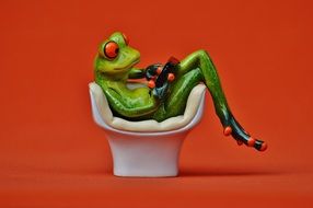 green frog figure in a white chair