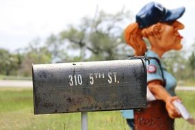 Mailwoman, funny figure at mailbox outdoor