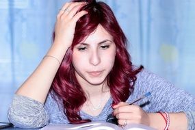 thoughtful girl writing in the notebook