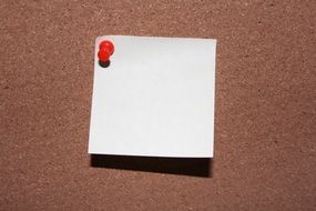 white note is pinned to corkboard