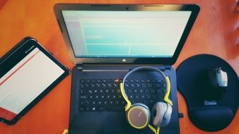 tablet and headphones near laptop