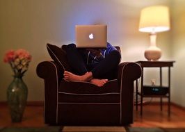 man in armchair with laptop