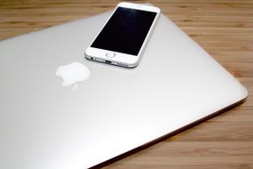 white smartphone lies on a laptop