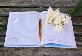 flowers and pen on an open notebook