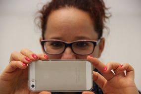 Photographer, woman in Glasses holds Mobile Phone