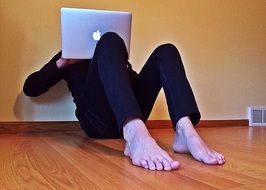 young man works on a computer on the floor