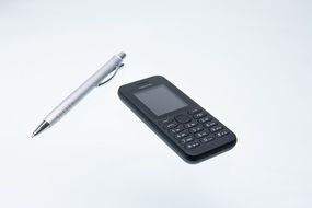silver pen and black mobile phone