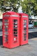 two red phone booths on the street of london