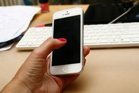 white smartphone in hand