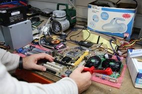 manâs hands at Computer hardware on table, repair