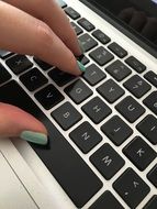 hands with green manicure on the keyboard