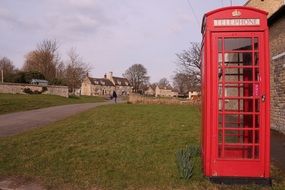 red telephone box in a green clearing