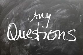 Any Questions sign on a board