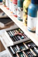 colorful pencils and paints on the shelf