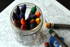colored pencils in a glass on the table close-up