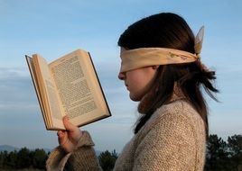 girl reading a book blindfolded