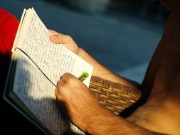 man Writing with Pen on notebook