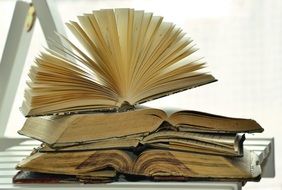 pile of Old open Books on table