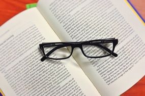 black Glasses on open book