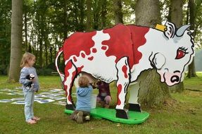 children milking a toy cow