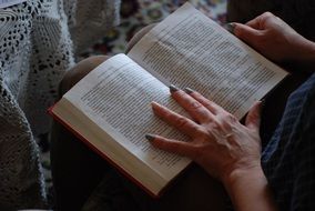 woman with manicure reads a book