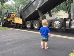 child near a huge truck