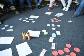 personsâ legs, paper cards and pensils on carpet, Group Work, Brainstorming