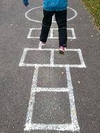 dild plays hopscotch on asphalt